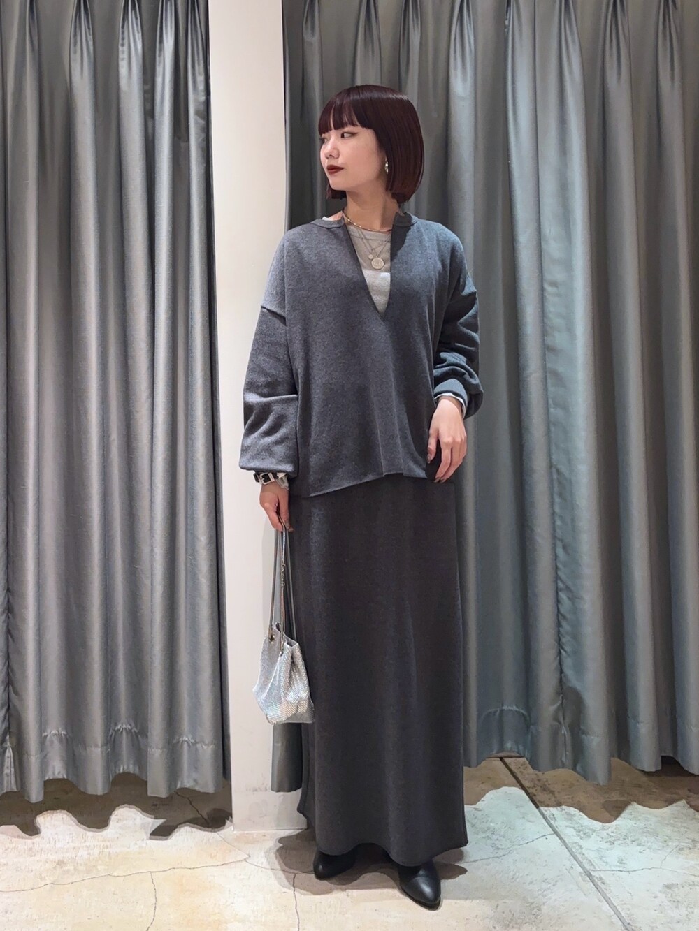 シルバー系のTシャツ/カットソー、グレー系のTシャツ/カットソー、グレー系のスカートを着用したレディースの冬コーディネートの2枚目の写真
