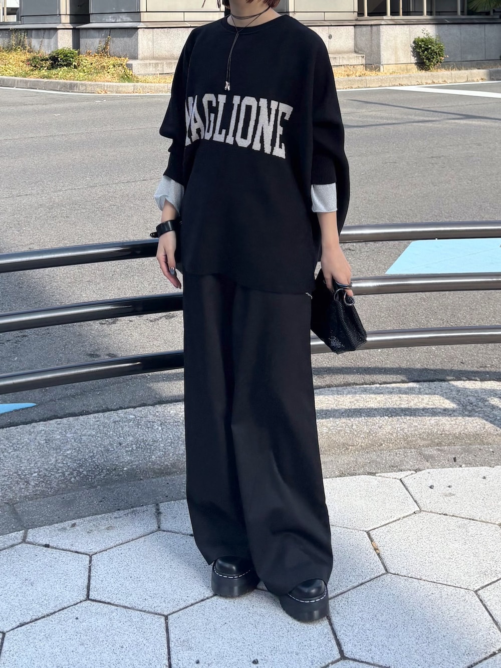 ブラック系のニット/セーター、ブラック系のその他パンツ、ブラック系のショルダーバッグを着用したレディースの冬コーディネートの5枚目の写真