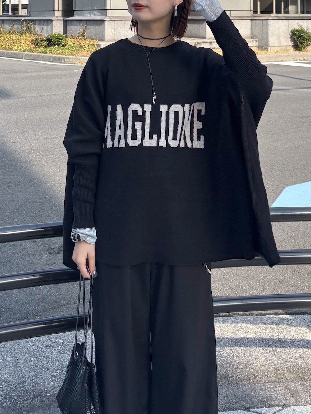 ブラック系のニット/セーター、ブラック系のその他パンツ、ブラック系のショルダーバッグを着用したレディースの冬コーディネートの7枚目の写真