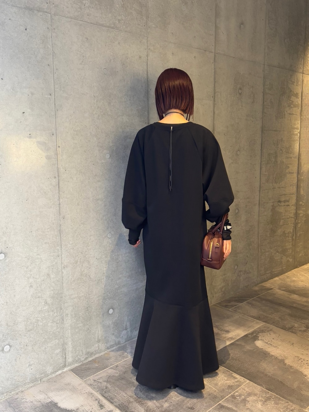 ブラック系のワンピース、ブラック系のTシャツ/カットソー、ブラウン系のショルダーバッグを着用したレディースの冬コーディネートの4枚目の写真