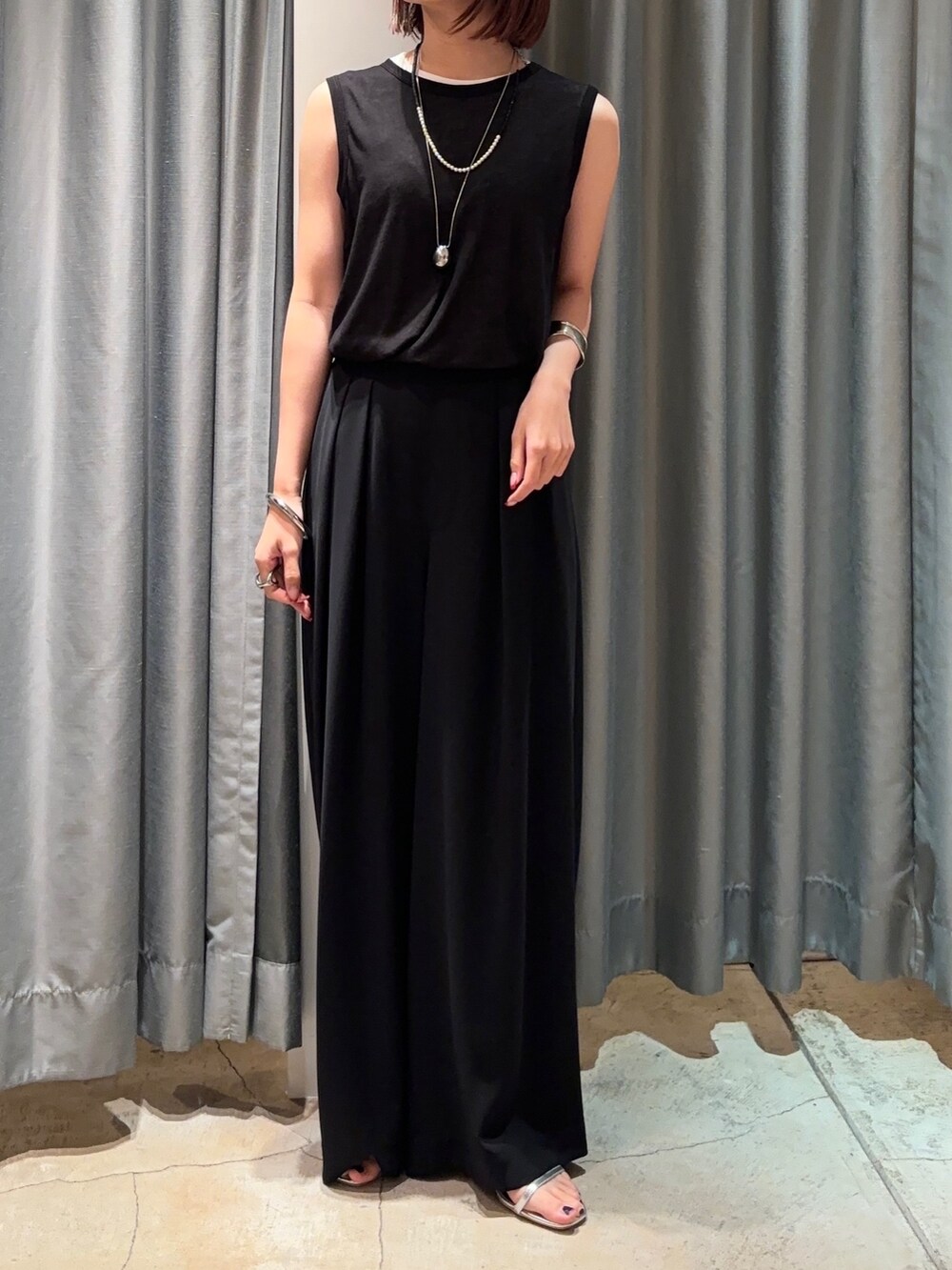 ブラック系のスラックス、ホワイト系のTシャツ/カットソー、ブラック系のTシャツ/カットソーを着用したレディースの夏コーディネートの5枚目の写真