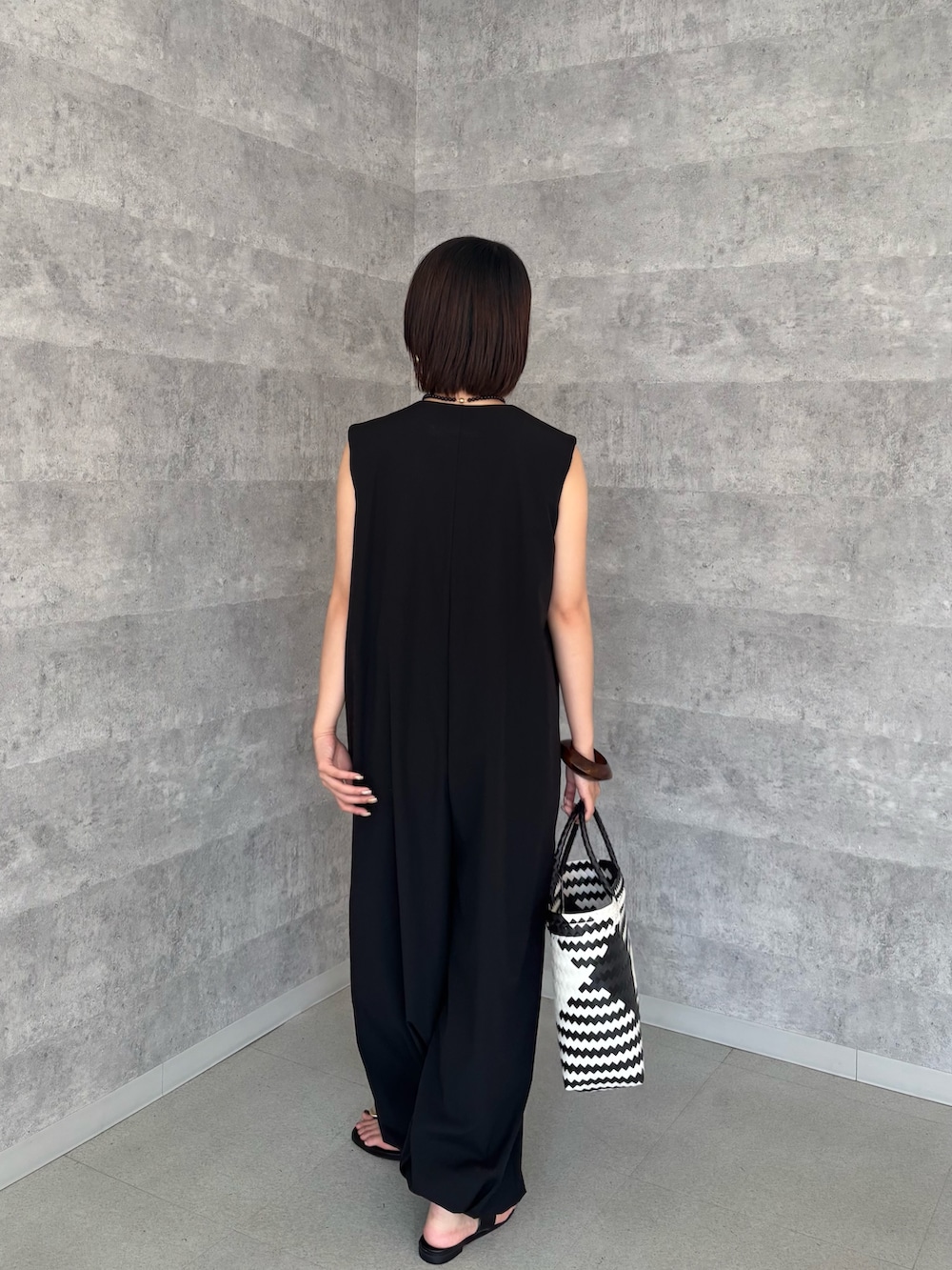 ブラック系のつなぎ/オールインワン、グレー系のタンクトップ、ブラック系のショルダーバッグを着用したレディースの夏コーディネートの4枚目の写真