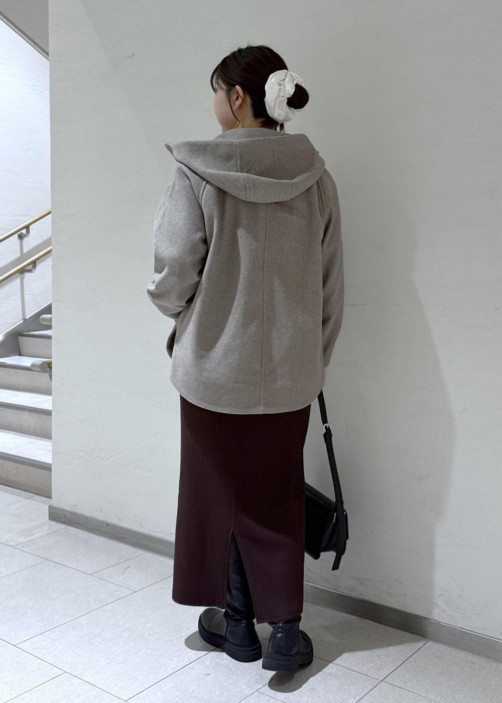 ブラック系のショルダーバッグ、ブラウン系のその他アウター、ホワイト系のニット/セーターを着用したレディースの冬コーディネートの3枚目の写真