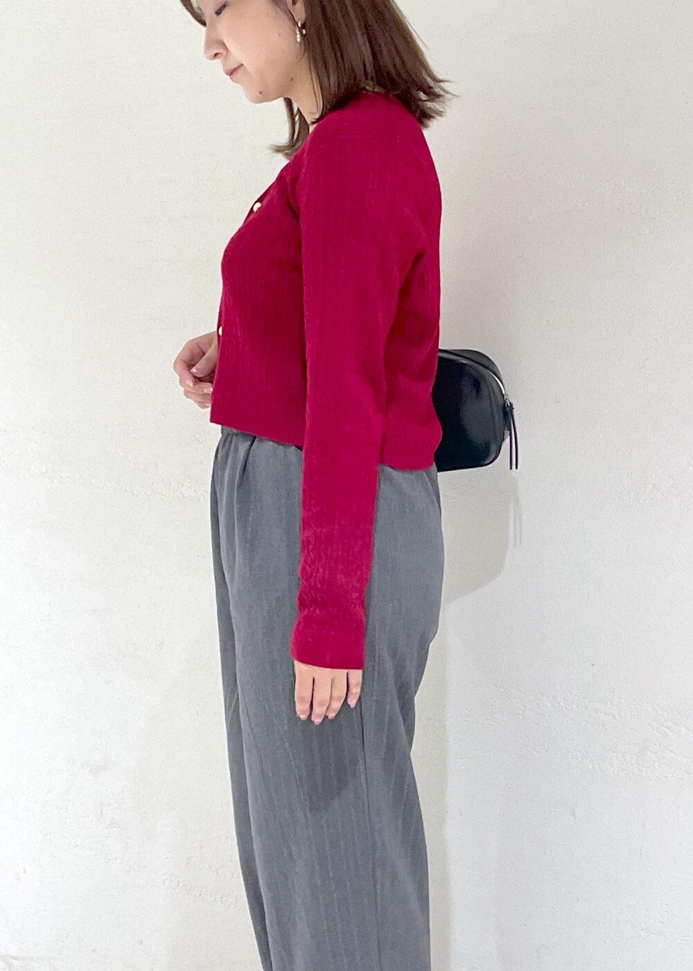 レッド系のカーディガン/ボレロ、グレー系のその他パンツ、ブラック系のボストンバッグを着用したレディースの秋コーディネートの7枚目の写真