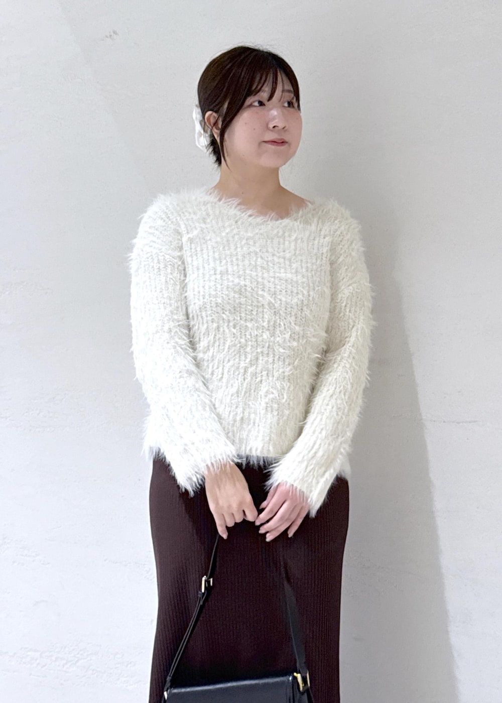 ブラック系のショルダーバッグ、ブラウン系のその他アウター、ホワイト系のニット/セーターを着用したレディースの冬コーディネートの10枚目の写真