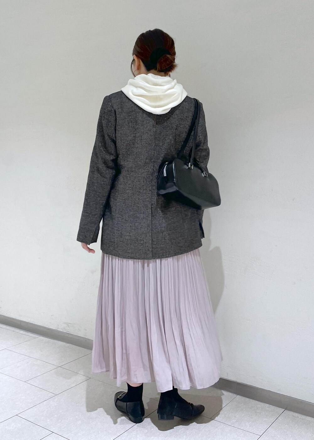 ホワイト系のパーカー、ブラック系のテーラードジャケット、ブラック系のボストンバッグを着用したレディースの秋コーディネートの5枚目の写真