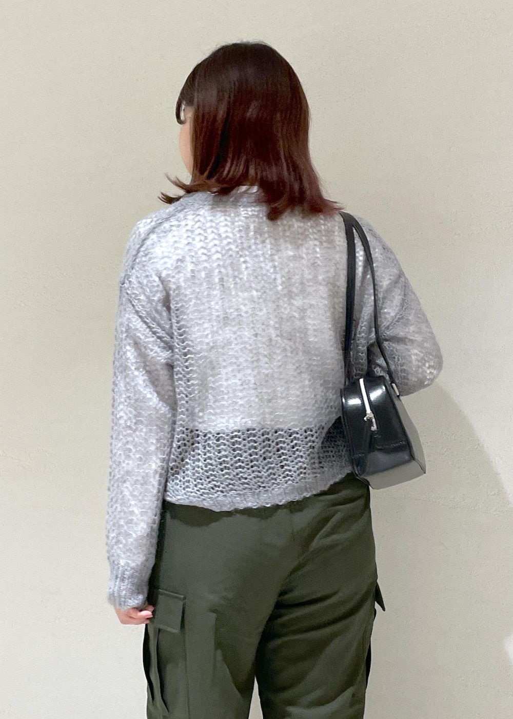 グレー系のニット/セーター、グリーン系のカーゴパンツ、ブラック系のボストンバッグを着用したレディースの秋コーディネートの9枚目の写真