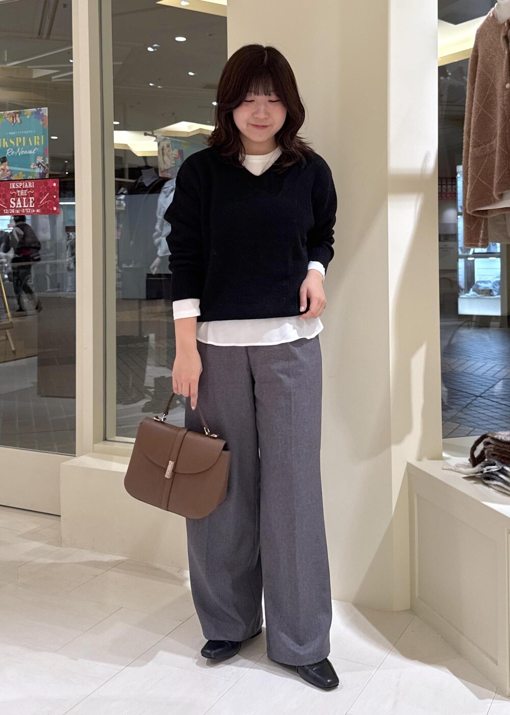 ホワイト系のTシャツ/カットソー、ブラック系のニット/セーター、グレー系のチェスターコートを着用したレディースの冬コーディネートの8枚目の写真