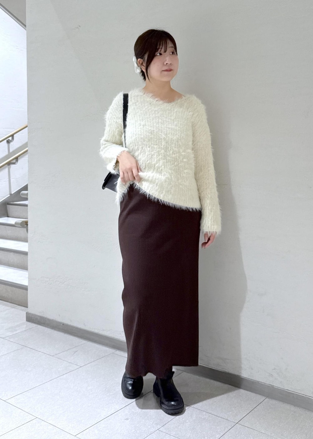 ブラック系のショルダーバッグ、ブラウン系のその他アウター、ホワイト系のニット/セーターを着用したレディースの冬コーディネートの7枚目の写真