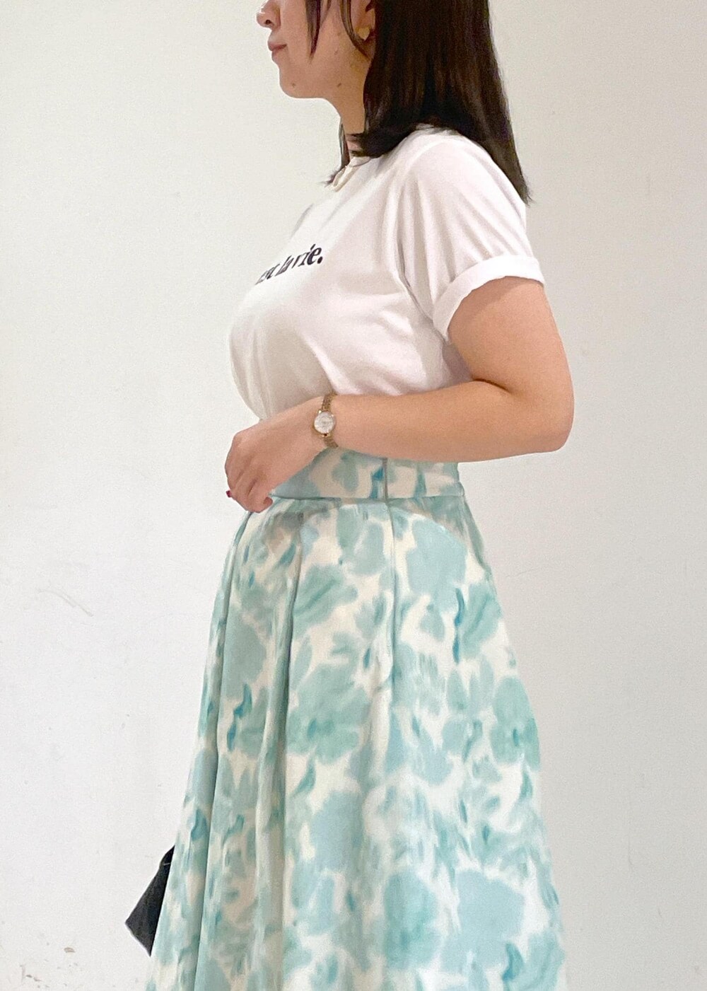 ブルー系のスカート、ブラック系のショルダーバッグ、ホワイト系のTシャツ/カットソーを着用したレディースの夏コーディネートの6枚目の写真