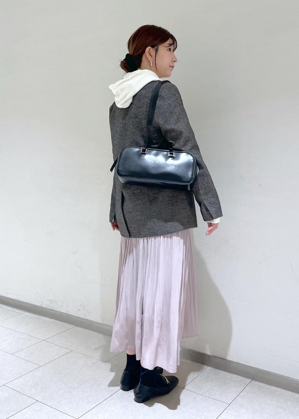 ホワイト系のパーカー、ブラック系のテーラードジャケット、ブラック系のボストンバッグを着用したレディースの秋コーディネートの4枚目の写真