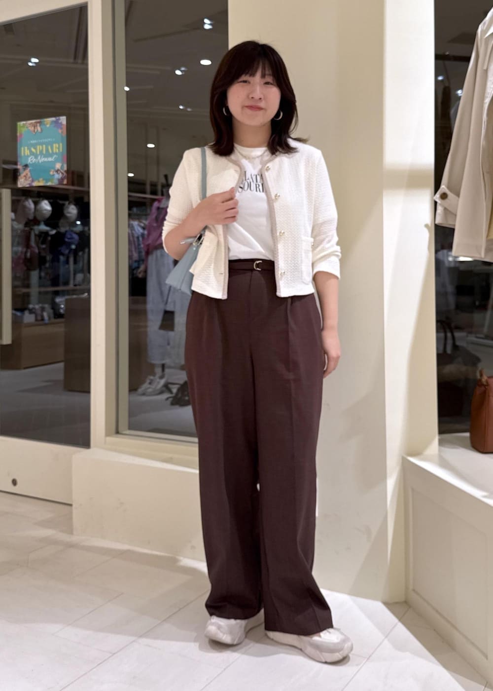 ブルー系のショルダーバッグ、ブラウン系のその他パンツ、ホワイト系のカーディガン/ボレロを着用したレディースの春コーディネートの2枚目の写真