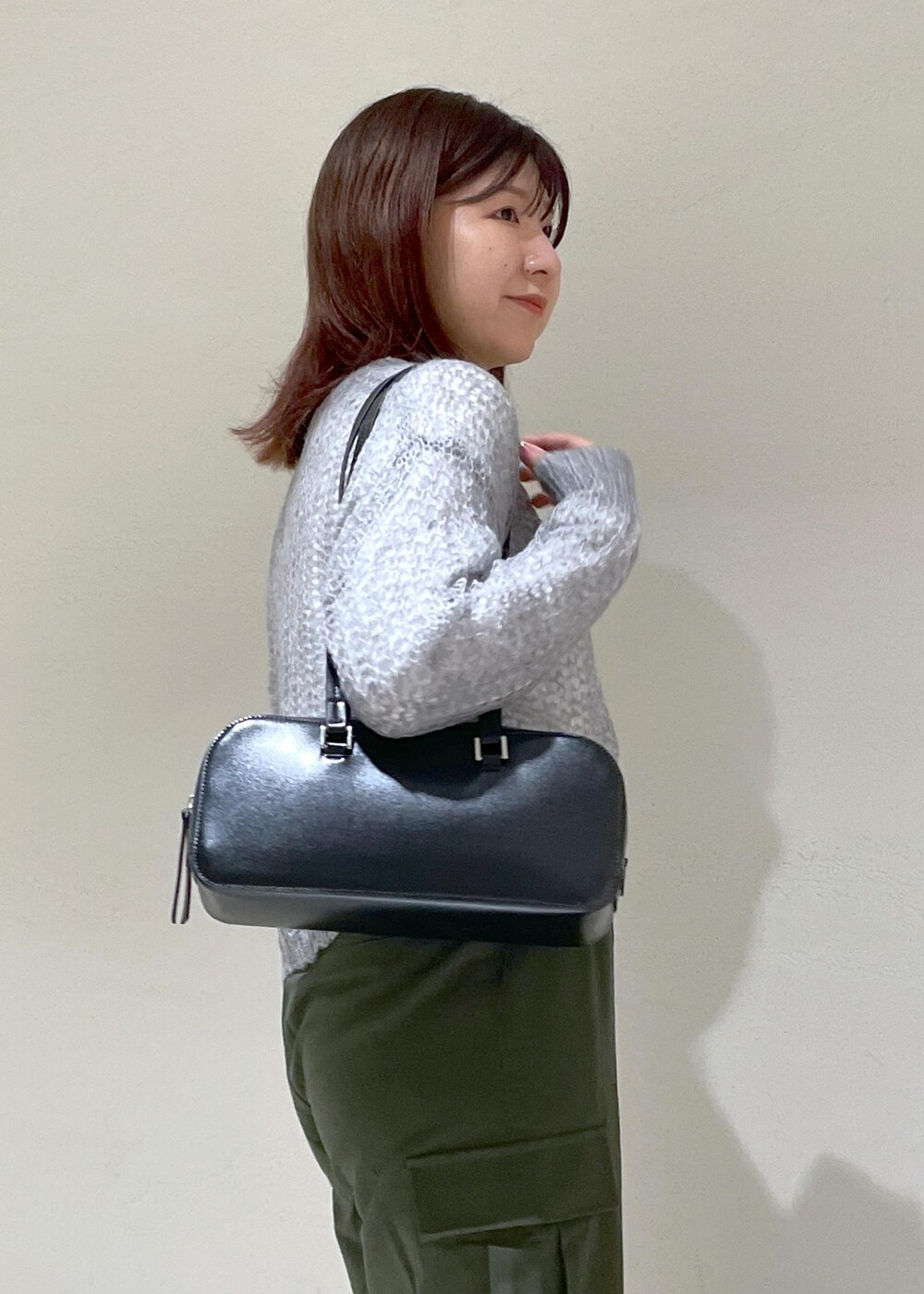 グレー系のニット/セーター、グリーン系のカーゴパンツ、ブラック系のボストンバッグを着用したレディースの秋コーディネートの8枚目の写真