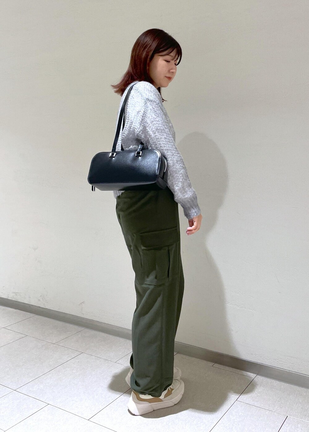 グレー系のニット/セーター、グリーン系のカーゴパンツ、ブラック系のボストンバッグを着用したレディースの秋コーディネートの4枚目の写真