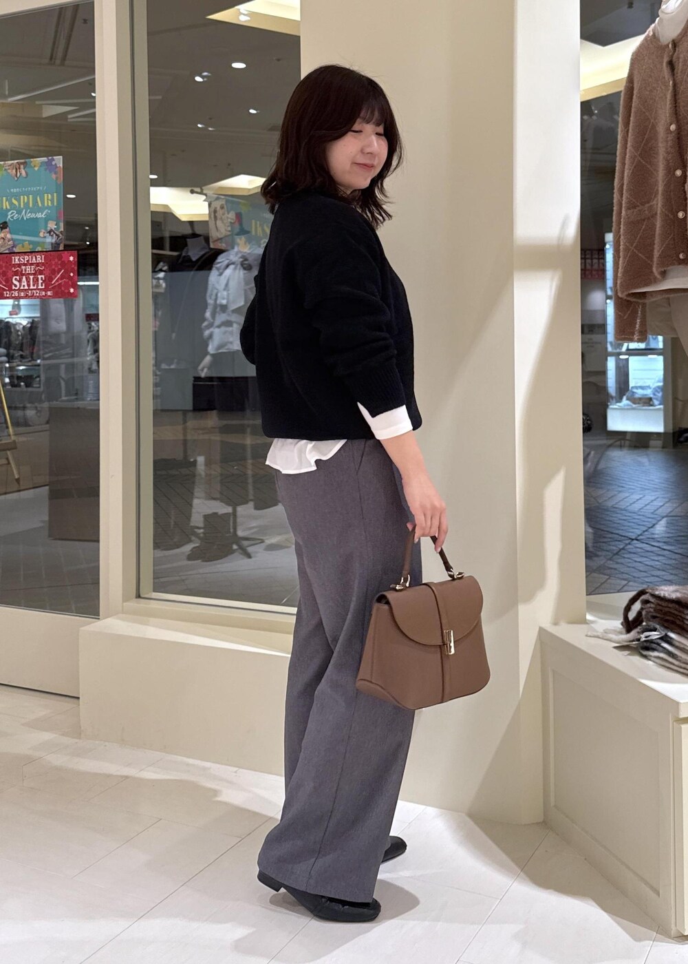 ホワイト系のTシャツ/カットソー、ブラック系のニット/セーター、グレー系のチェスターコートを着用したレディースの冬コーディネートの10枚目の写真