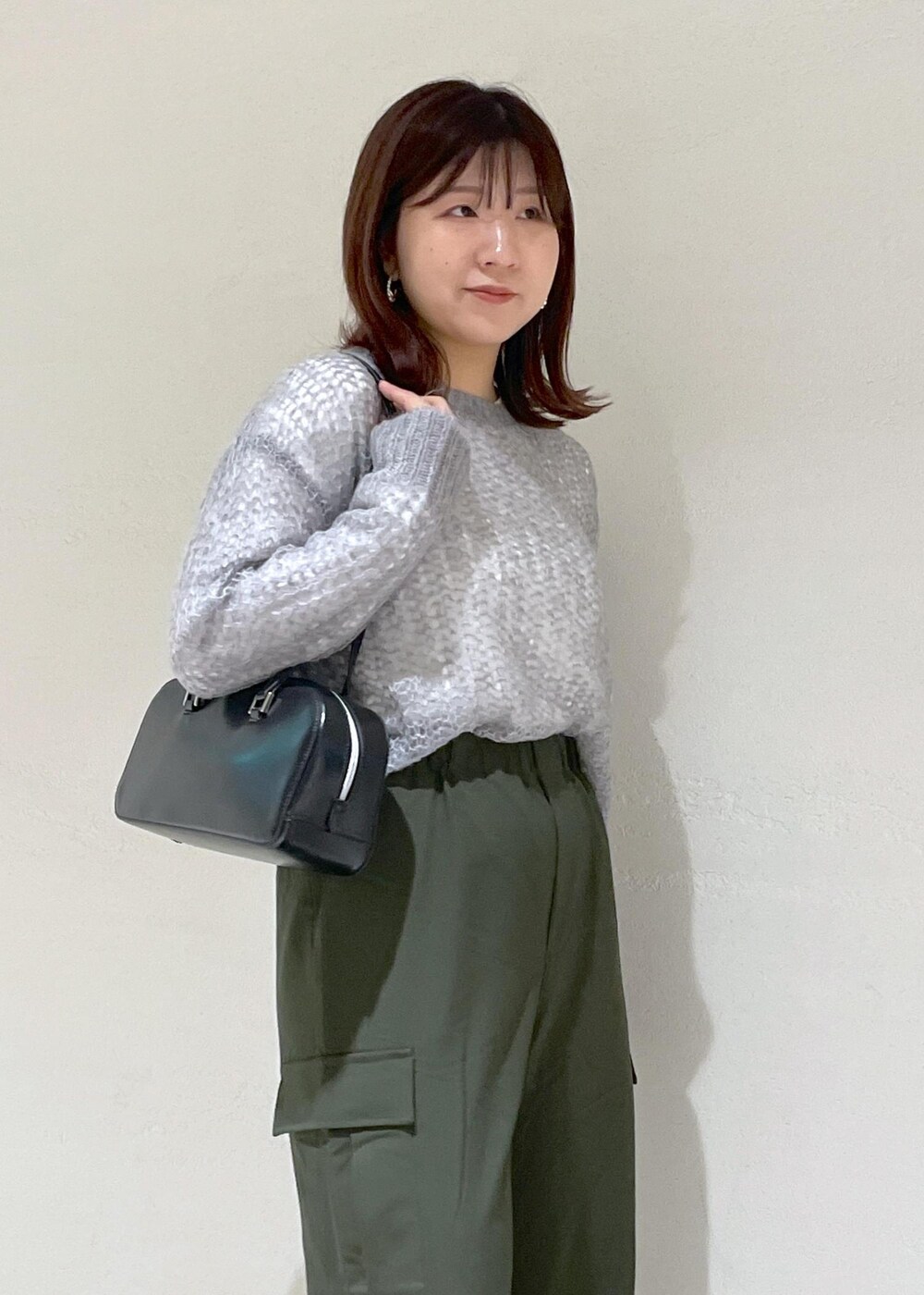 グレー系のニット/セーター、グリーン系のカーゴパンツ、ブラック系のボストンバッグを着用したレディースの秋コーディネートの7枚目の写真