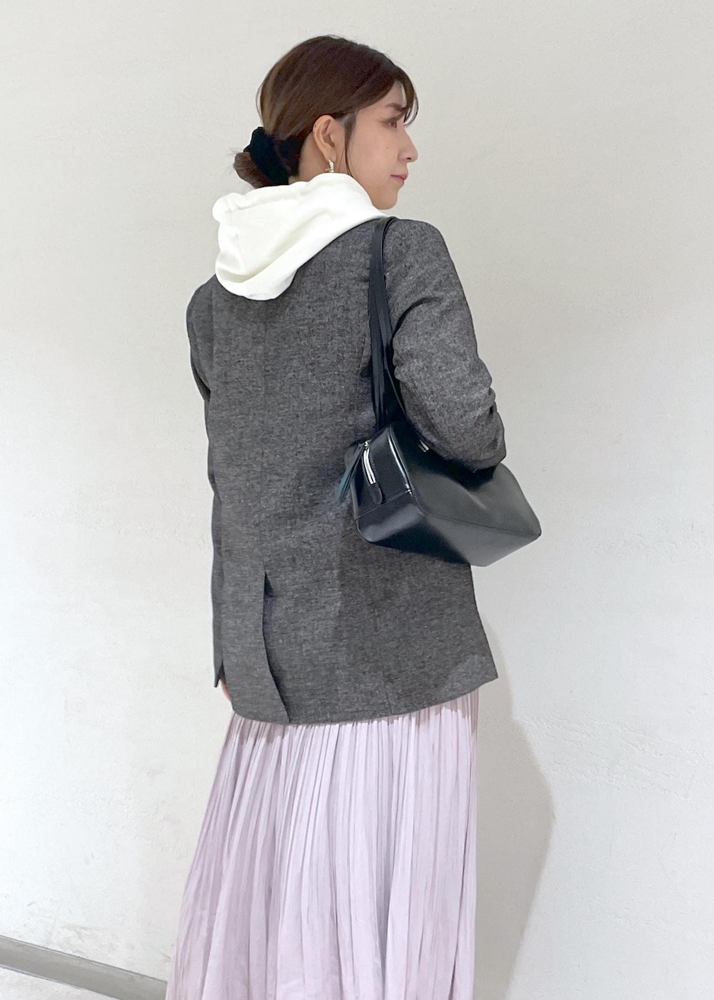 ホワイト系のパーカー、ブラック系のテーラードジャケット、ブラック系のボストンバッグを着用したレディースの秋コーディネートの9枚目の写真