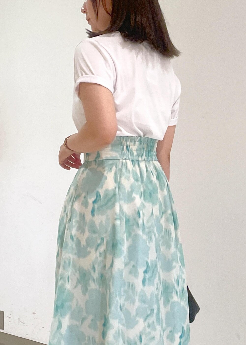 ブルー系のスカート、ブラック系のショルダーバッグ、ホワイト系のTシャツ/カットソーを着用したレディースの夏コーディネートの7枚目の写真