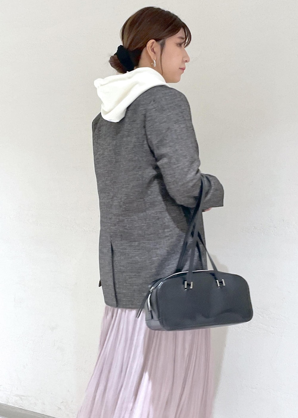 ホワイト系のパーカー、ブラック系のテーラードジャケット、ブラック系のボストンバッグを着用したレディースの秋コーディネートの8枚目の写真