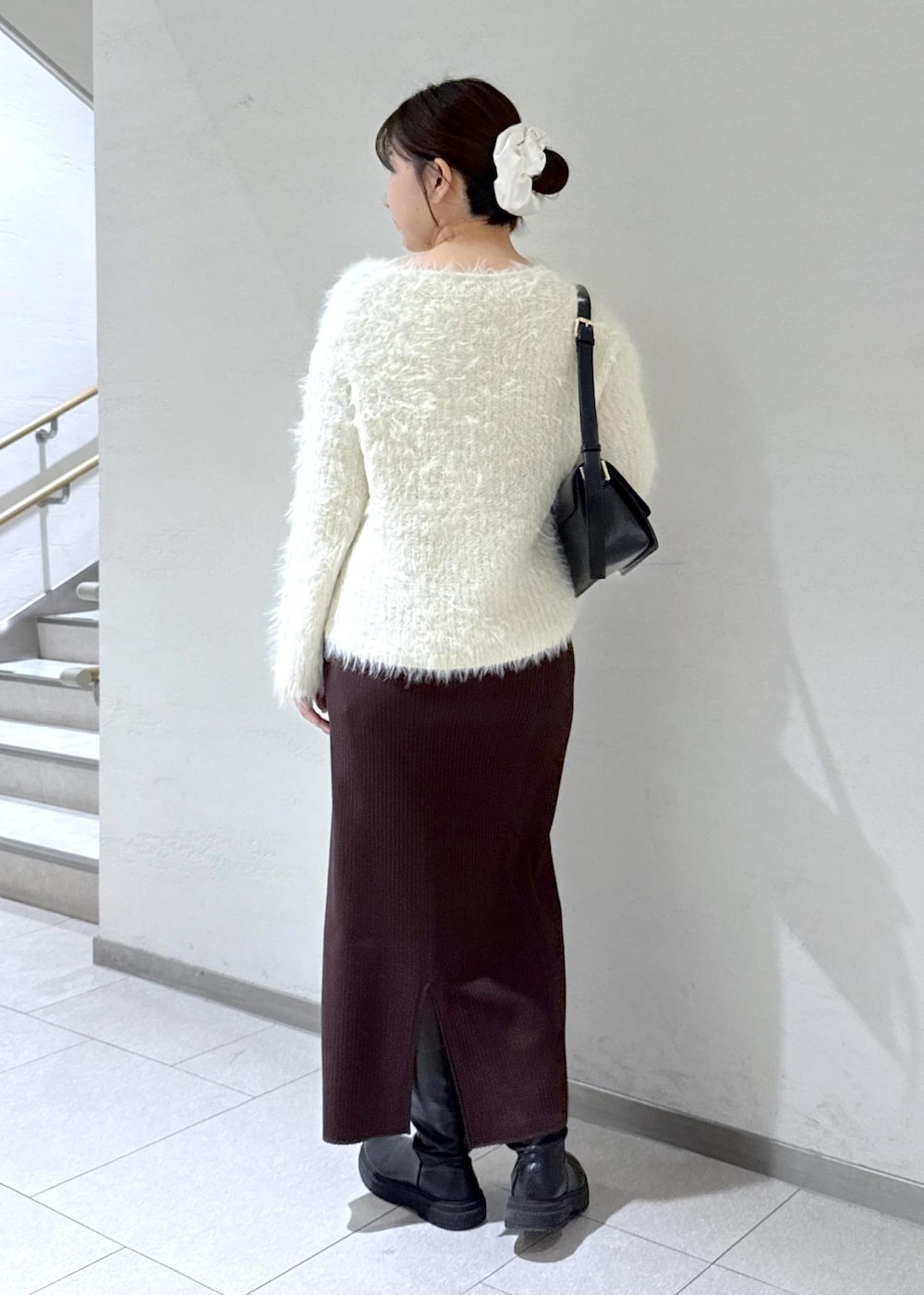 ブラック系のショルダーバッグ、ブラウン系のその他アウター、ホワイト系のニット/セーターを着用したレディースの冬コーディネートの9枚目の写真