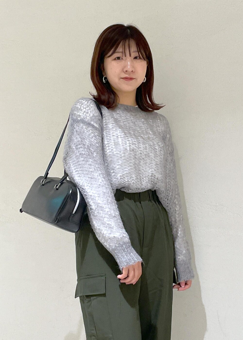 グレー系のニット/セーター、グリーン系のカーゴパンツ、ブラック系のボストンバッグを着用したレディースの秋コーディネートの10枚目の写真