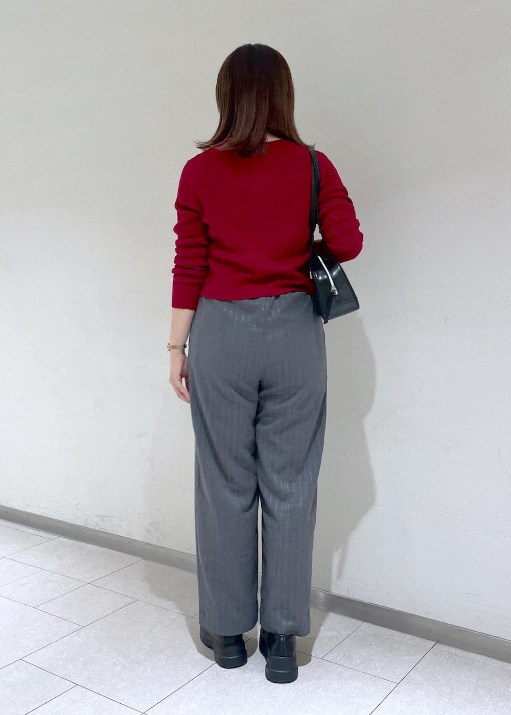 レッド系のカーディガン/ボレロ、グレー系のその他パンツ、ブラック系のボストンバッグを着用したレディースの秋コーディネートの5枚目の写真