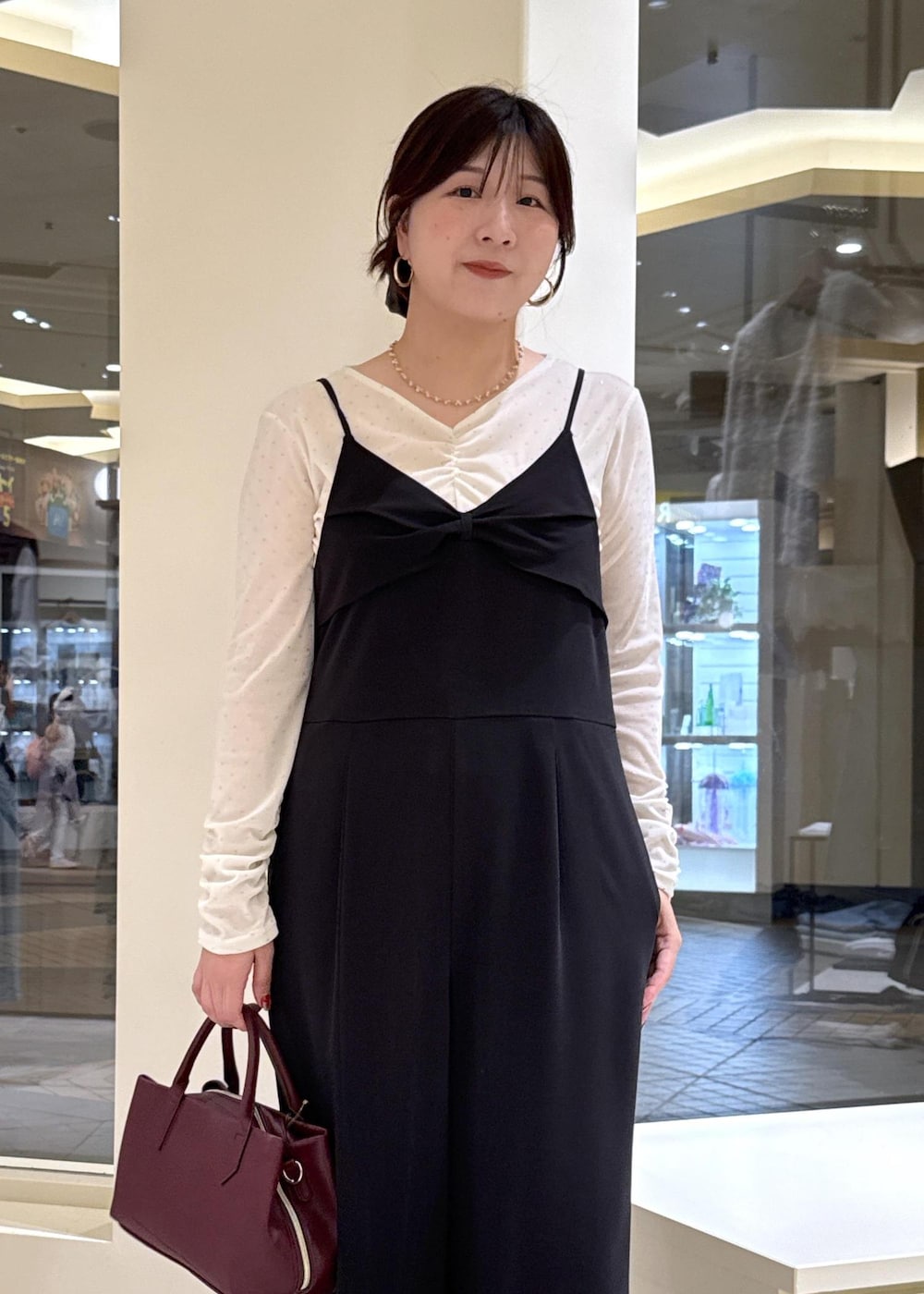 ブラウン系のローファー、レッド系のトートバッグ、ブラック系のつなぎ/オールインワンを着用したレディースの秋コーディネートの5枚目の写真