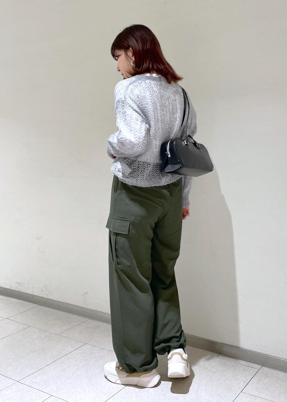 グレー系のニット/セーター、グリーン系のカーゴパンツ、ブラック系のボストンバッグを着用したレディースの秋コーディネートの5枚目の写真