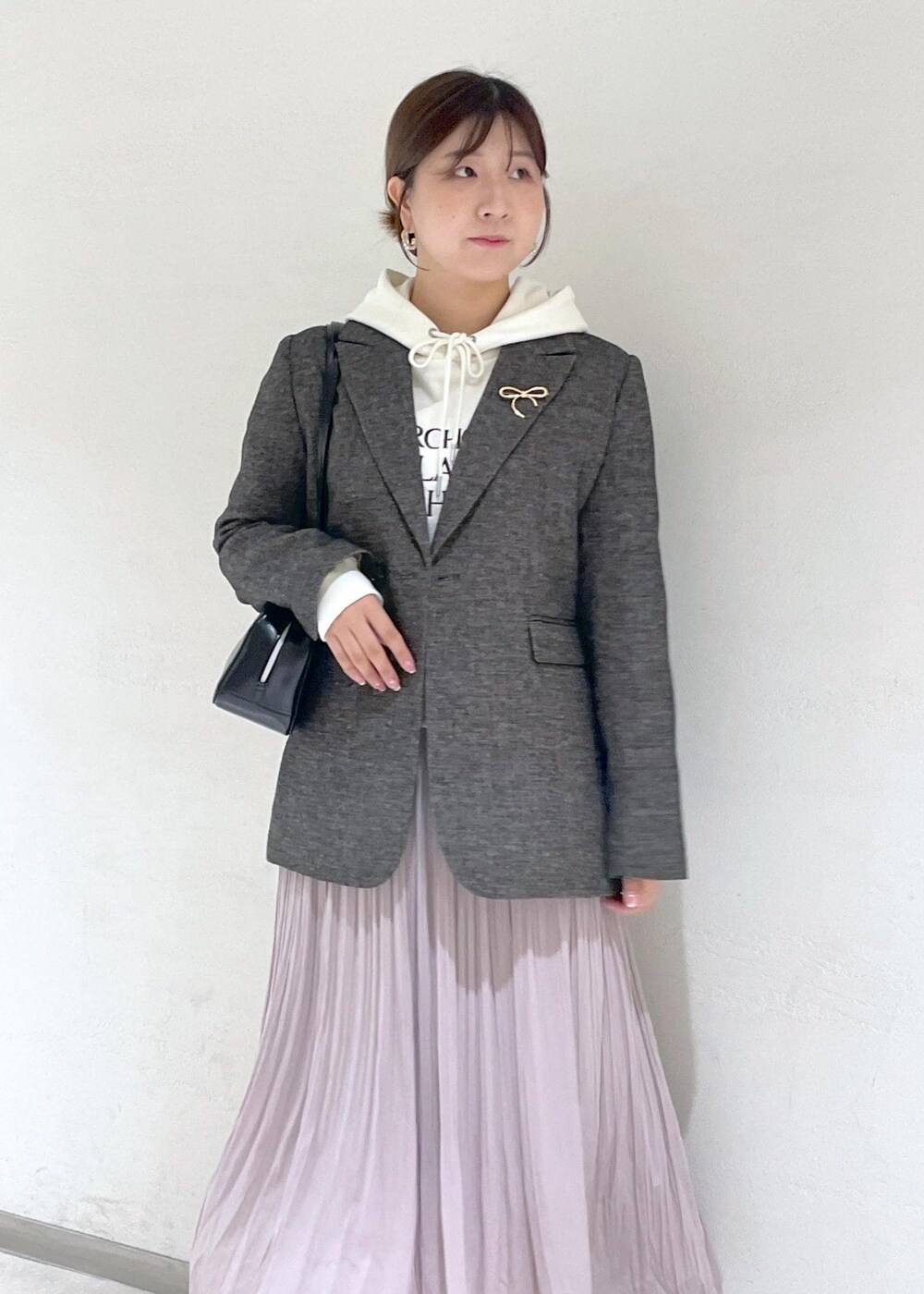 ホワイト系のパーカー、ブラック系のテーラードジャケット、ブラック系のボストンバッグを着用したレディースの秋コーディネートの7枚目の写真