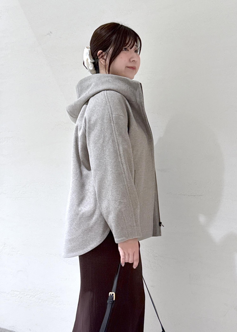 ブラック系のショルダーバッグ、ブラウン系のその他アウター、ホワイト系のニット/セーターを着用したレディースの冬コーディネートの5枚目の写真