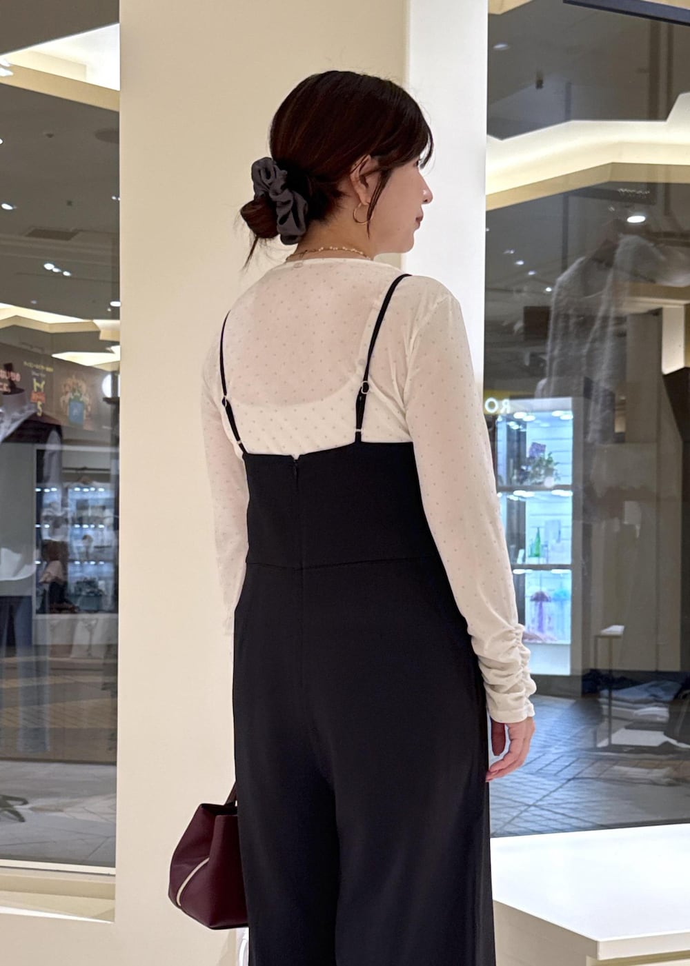 ブラウン系のローファー、レッド系のトートバッグ、ブラック系のつなぎ/オールインワンを着用したレディースの秋コーディネートの7枚目の写真