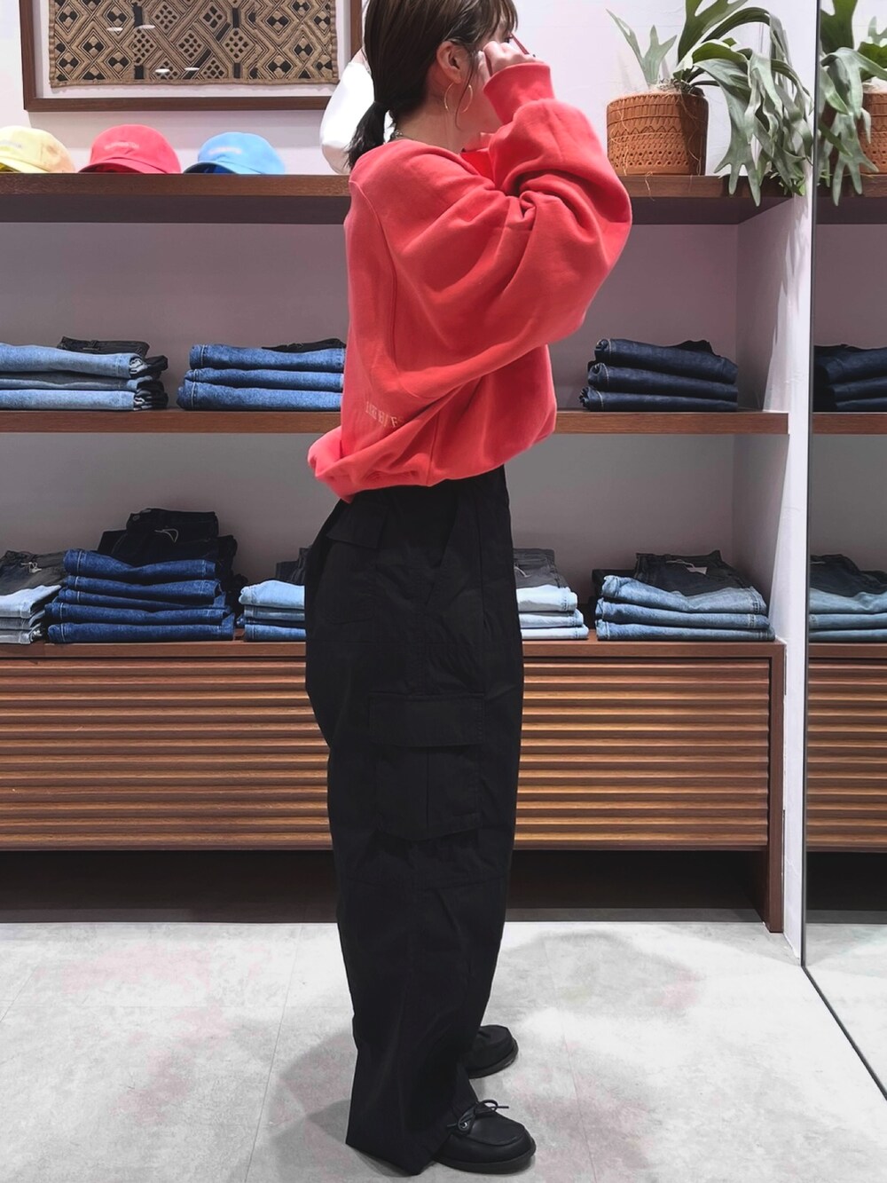 レッド系のスウェット、ブラック系のその他パンツ、ブラック系のローファーを着用したレディースの春コーディネートの3枚目の写真