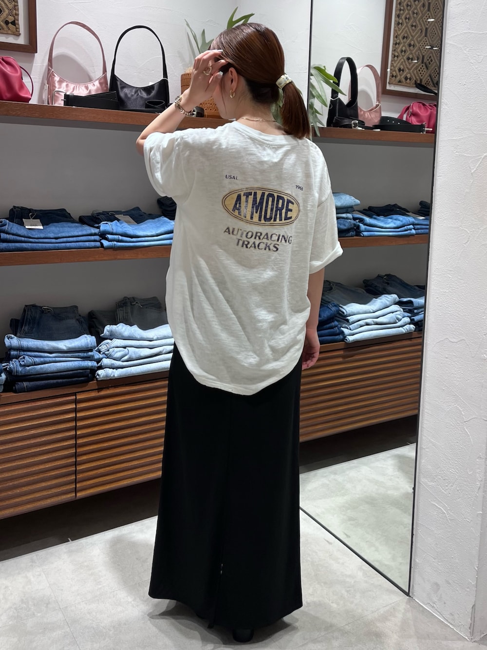 ホワイト系のTシャツ/カットソー、ベージュ系のショルダーバッグ、ブラック系のスカートを着用したレディースの春コーディネートの4枚目の写真