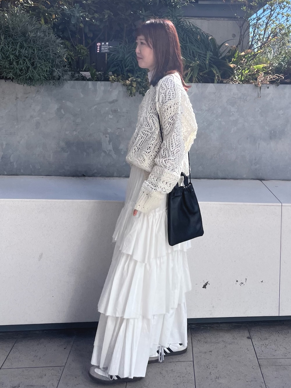 ホワイト系のニット/セーター、ホワイト系のスカート、パープル系のTシャツ/カットソーを着用したレディースの冬コーディネートの3枚目の写真