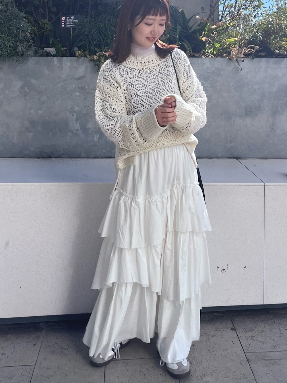 ホワイト系のニット/セーター、ホワイト系のスカート、パープル系のTシャツ/カットソーを着用したレディースの冬コーディネートの5枚目の写真