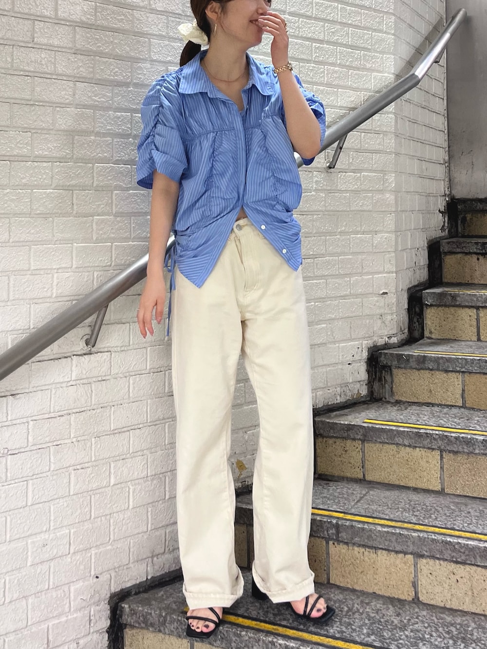 ブルー系のシャツ/ブラウス、ホワイト系のデニムパンツを着用したレディースの春コーディネートの2枚目の写真