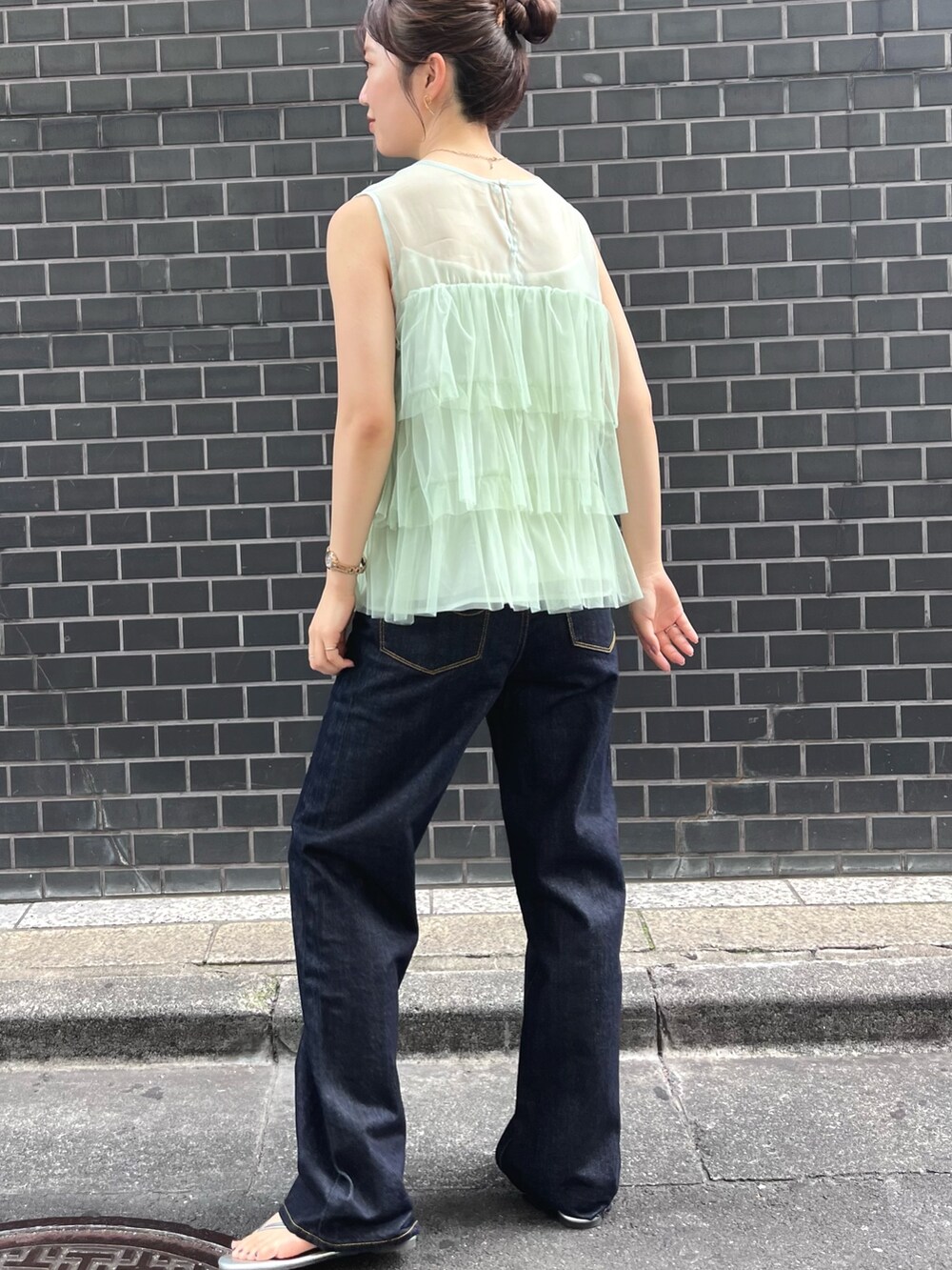 グリーン系のシャツ/ブラウス、ブルー系のデニムパンツを着用したレディースの夏コーディネートの3枚目の写真