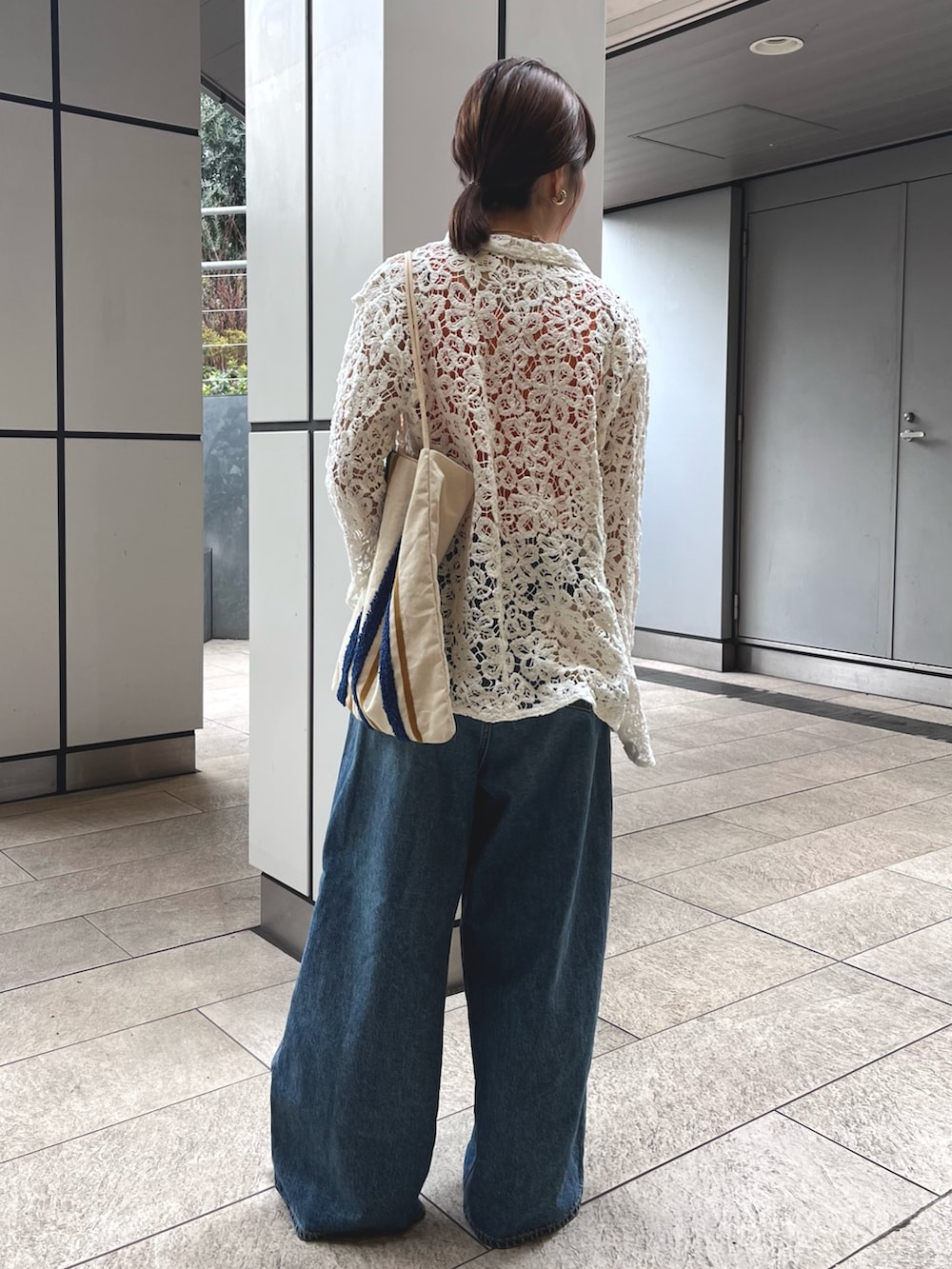 ブルー系のデニムパンツ、オレンジ系のタンクトップ、ホワイト系のシャツ/ブラウスを着用したレディースの春コーディネートの4枚目の写真