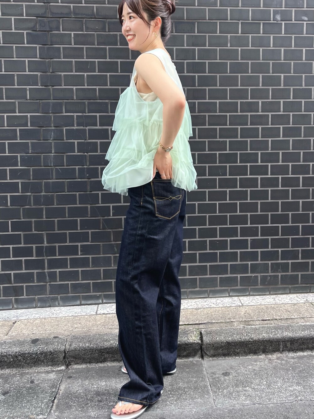 グリーン系のシャツ/ブラウス、ブルー系のデニムパンツを着用したレディースの夏コーディネートの2枚目の写真