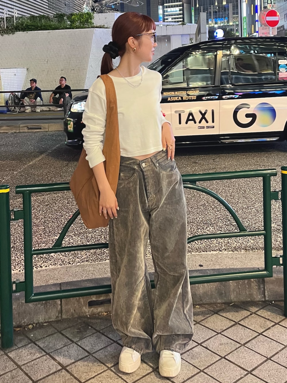 ホワイト系のTシャツ/カットソー、ベージュ系のデニムパンツ、ブラウン系のトートバッグを着用したレディースの秋コーディネートの2枚目の写真