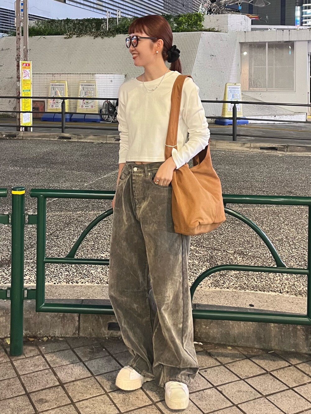 ホワイト系のTシャツ/カットソー、ベージュ系のデニムパンツ、ブラウン系のトートバッグを着用したレディースの秋コーディネートの5枚目の写真