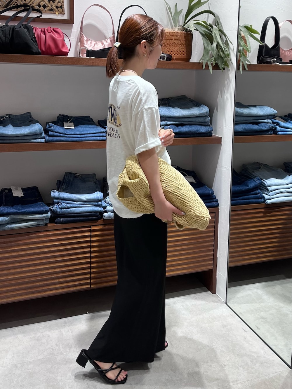 ホワイト系のTシャツ/カットソー、ベージュ系のショルダーバッグ、ブラック系のスカートを着用したレディースの春コーディネートの3枚目の写真