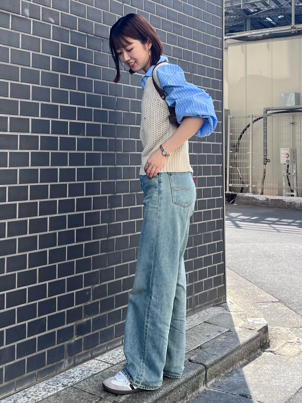 ブルー系のデニムパンツ、ホワイト系のニット/セーター、ブルー系のシャツ/ブラウスを着用したレディースの秋コーディネートの4枚目の写真