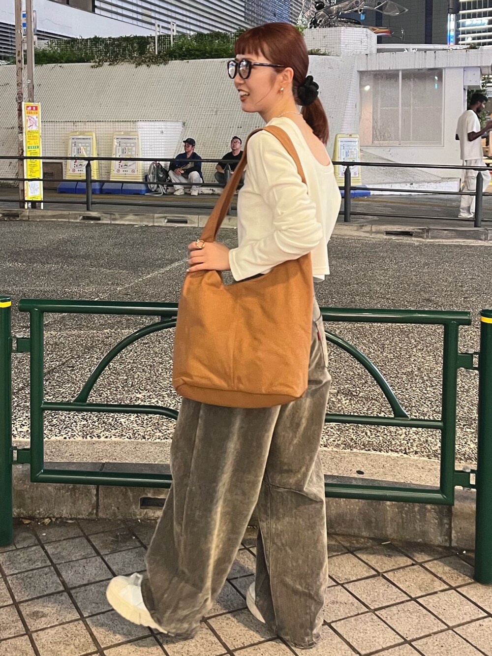 ホワイト系のTシャツ/カットソー、ベージュ系のデニムパンツ、ブラウン系のトートバッグを着用したレディースの秋コーディネートの3枚目の写真