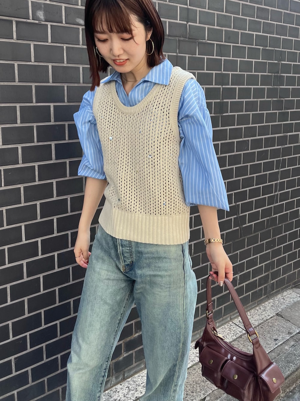 ブルー系のデニムパンツ、ホワイト系のニット/セーター、ブルー系のシャツ/ブラウスを着用したレディースの秋コーディネートの6枚目の写真