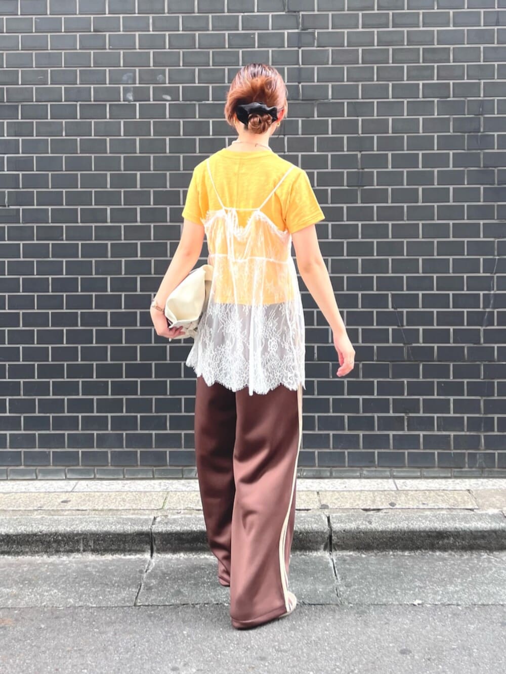 イエロー系のTシャツ/カットソー、ホワイト系のキャミソール、ホワイト系のハンドバッグを着用したレディースの夏コーディネートの5枚目の写真