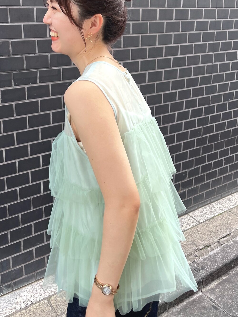 グリーン系のシャツ/ブラウス、ブルー系のデニムパンツを着用したレディースの夏コーディネートの4枚目の写真