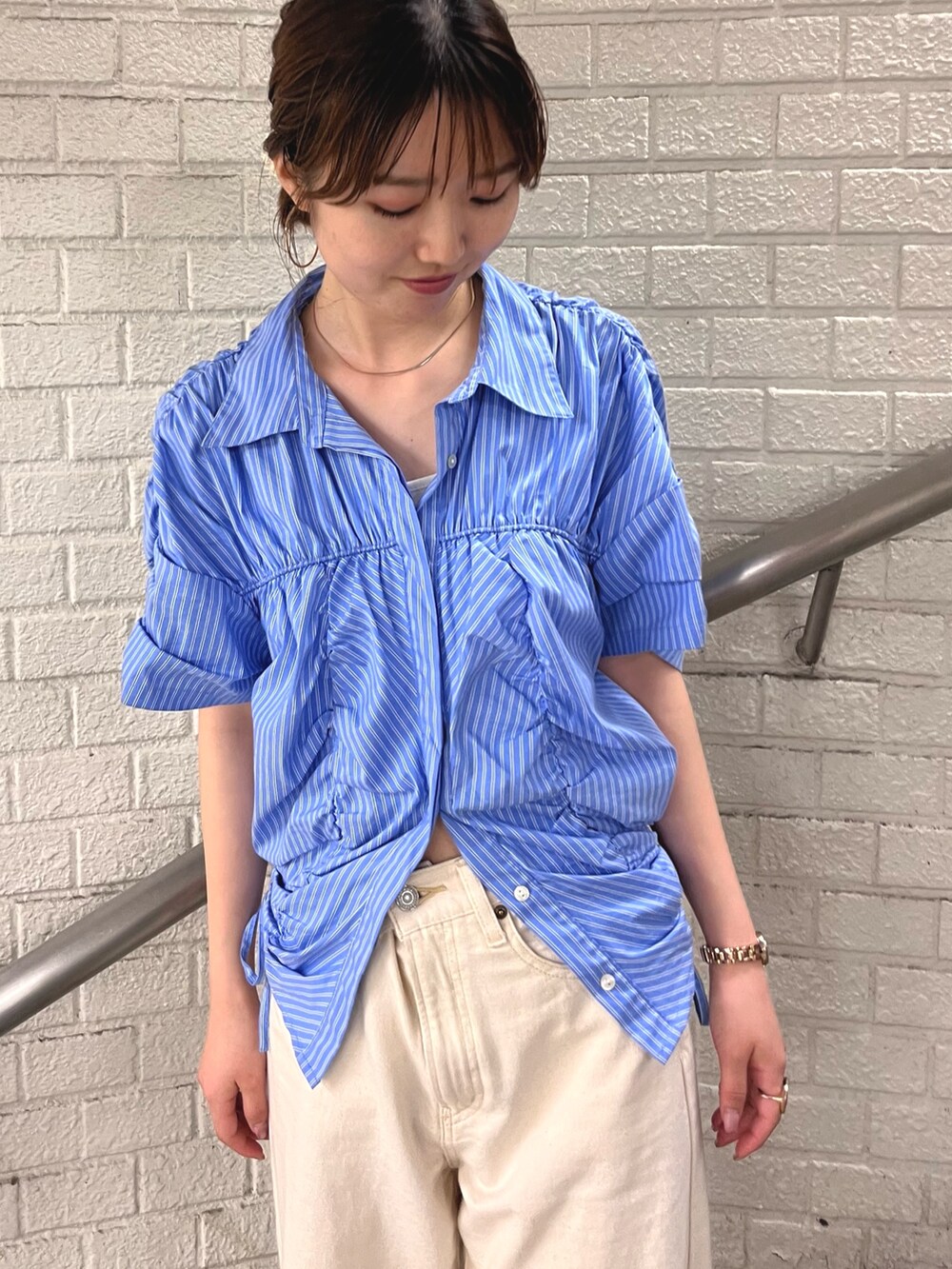 ブルー系のシャツ/ブラウス、ホワイト系のデニムパンツを着用したレディースの春コーディネートの6枚目の写真