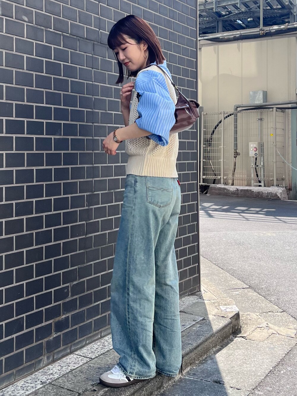 ブルー系のデニムパンツ、ホワイト系のニット/セーター、ブルー系のシャツ/ブラウスを着用したレディースの秋コーディネートの3枚目の写真