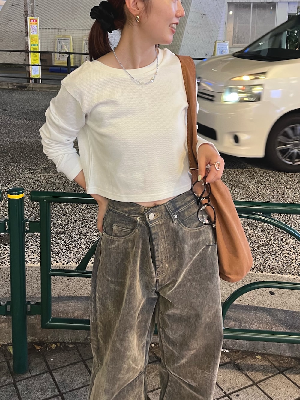 ホワイト系のTシャツ/カットソー、ベージュ系のデニムパンツ、ブラウン系のトートバッグを着用したレディースの秋コーディネートの6枚目の写真